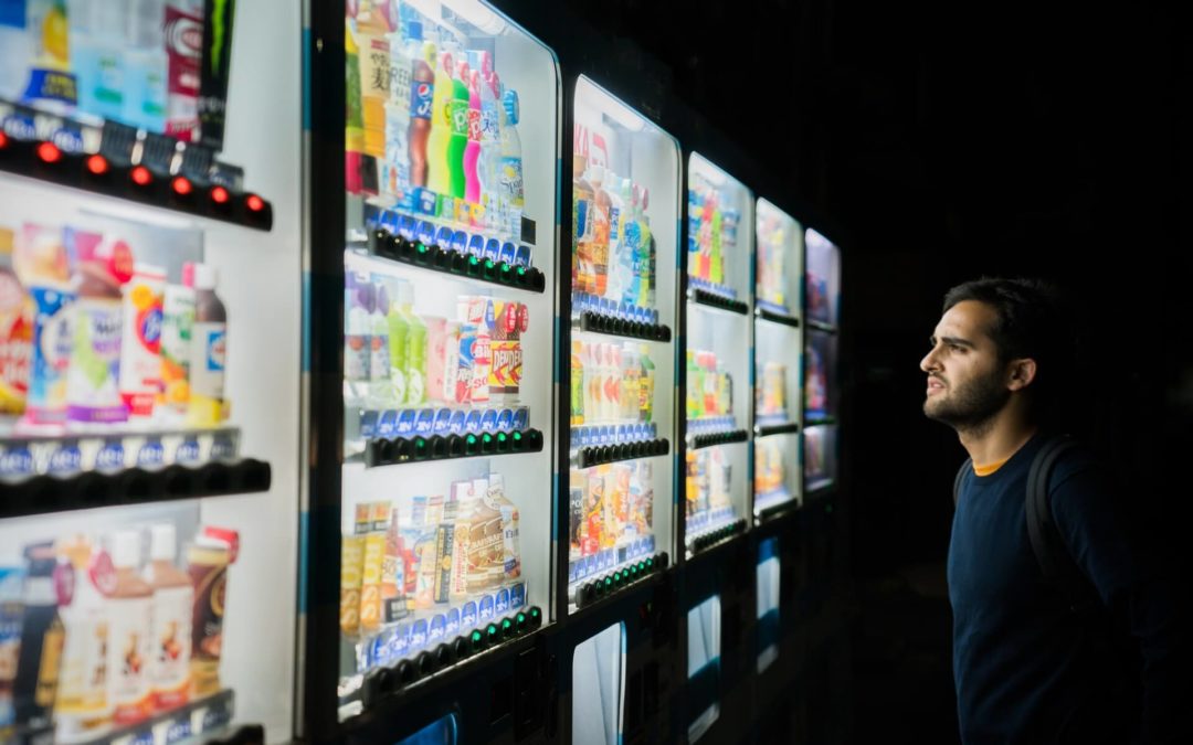 image of man considering vending machine choices from 6 vending machines with too many options. Intended as a metaphor for choosing a domain name extension and the almost infinite number of choices and configurarions of domain names and extensions such as dot com or dot org etc.